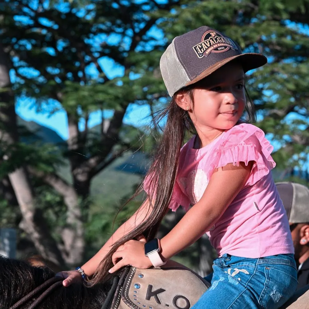 Criança a cavalo usando boné personalizado com bordado de cavalgada