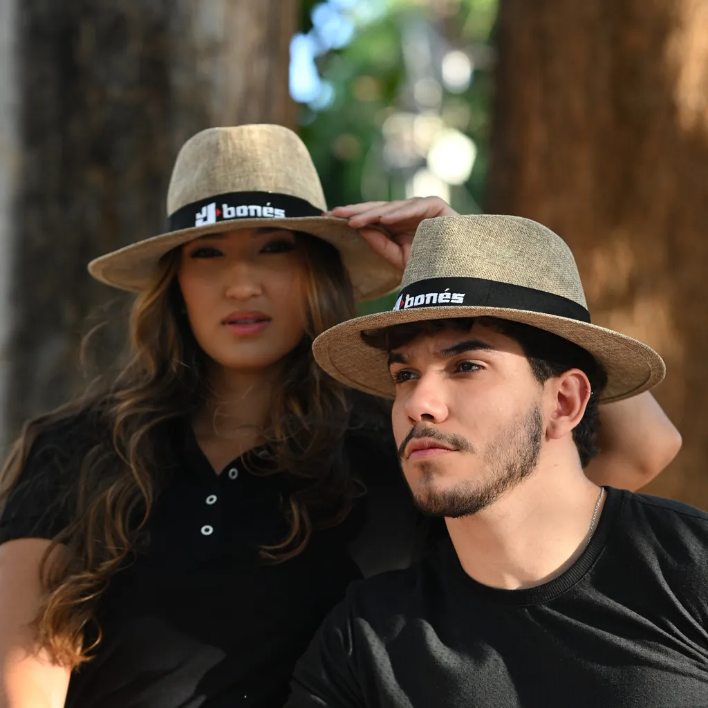 Casal usando chapéus de palha personalizados com faixa bordada